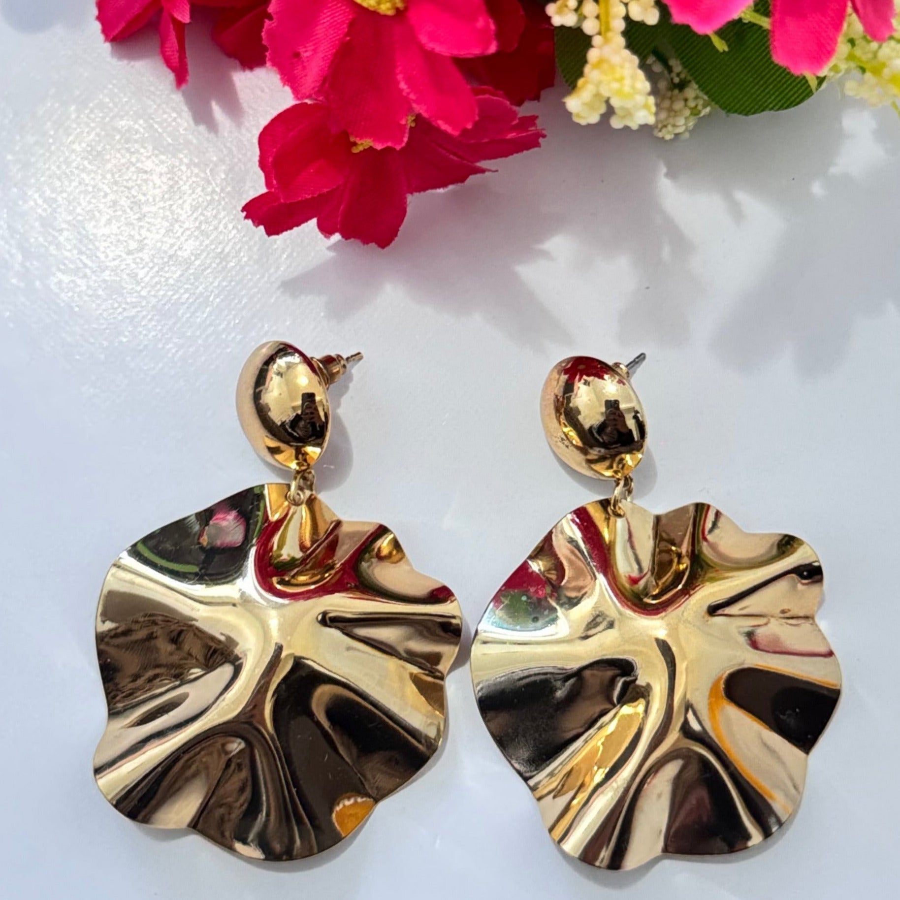 Unleash your inner elegance with these breathtaking gold statement earrings, designed to capture light and attention with every movement. Featuring a unique sculptural design inspired by the natural flow of molten gold, these earrings exude luxury, sophistication, and modern artistry. The fluid, wavy texture reflects light beautifully, adding a bold yet refined touch to any outfit.