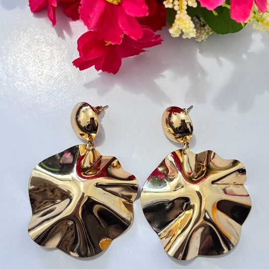 Unleash your inner elegance with these breathtaking gold statement earrings, designed to capture light and attention with every movement. Featuring a unique sculptural design inspired by the natural flow of molten gold, these earrings exude luxury, sophistication, and modern artistry. The fluid, wavy texture reflects light beautifully, adding a bold yet refined touch to any outfit.