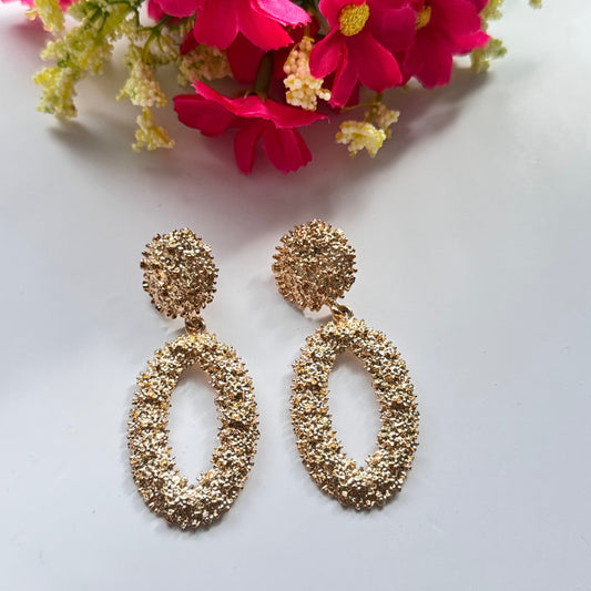 Dazzle in elegance with these stunning gold-tone textured earrings, designed to make a bold yet sophisticated statement. Featuring a unique organic finish that shimmers with every movement, these oval drop earrings bring a touch of luxury to any outfit.