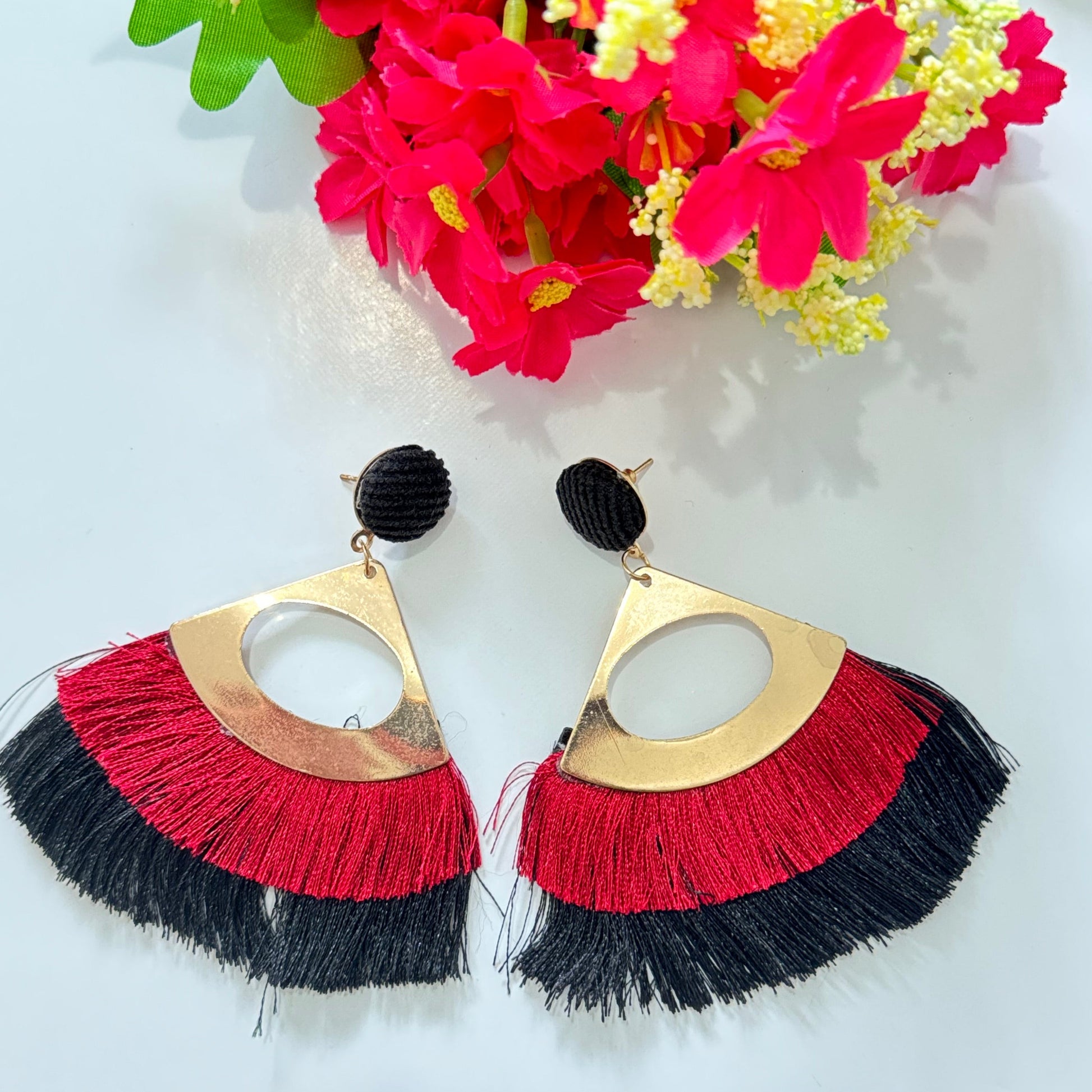  Featuring a sleek gold-tone geometric frame, these eye-catching accessories are adorned with a stunning fringe in striking red and black, adding a dramatic flair to any look. The lightweight, flowy tassels create a mesmerizing movement, making them the perfect standout piece for special occasions or everyday glam. 