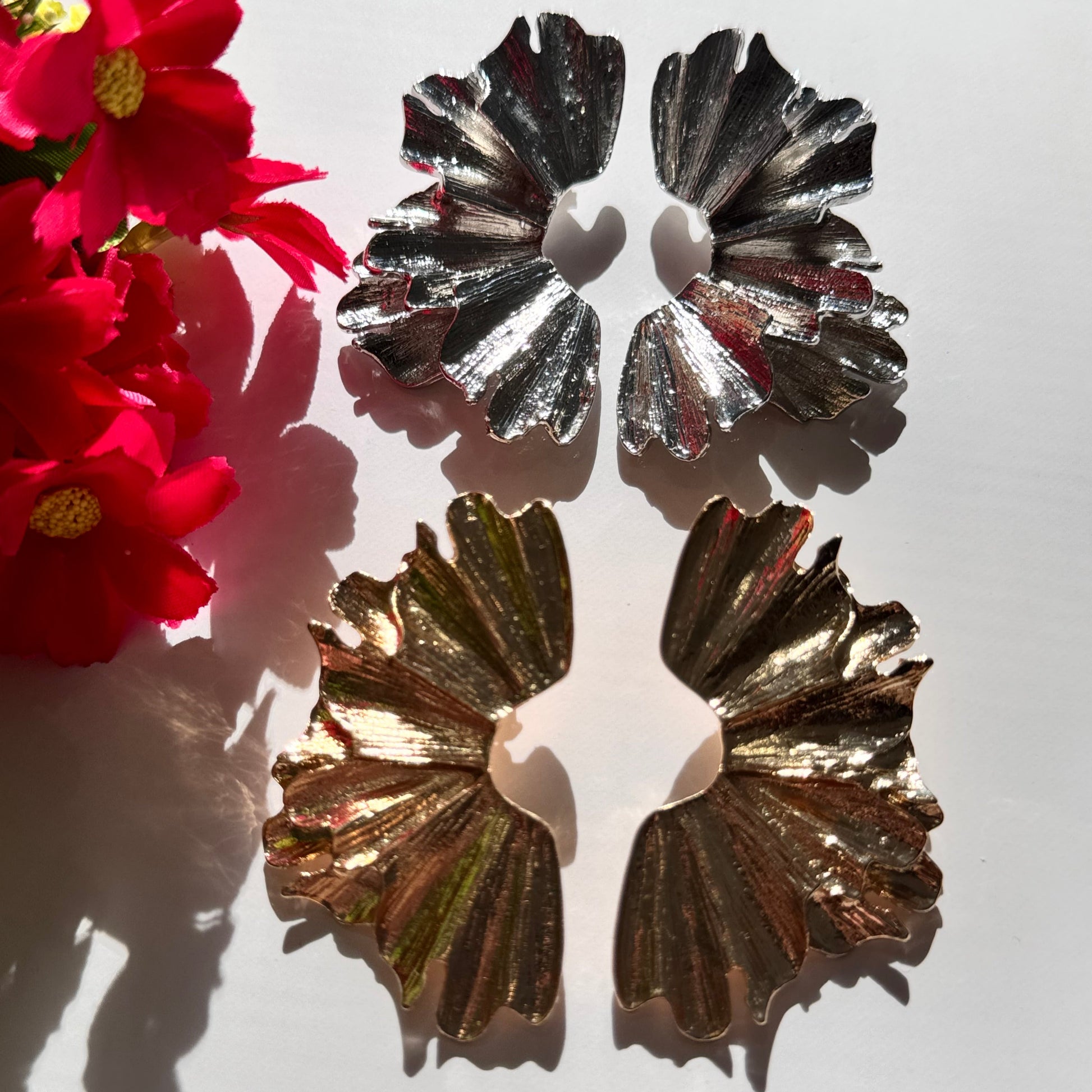 A true statement of elegance and bold sophistication. Crafted with a luxurious sculpted design, these earrings mimic the organic beauty of delicate wings, available in both radiant gold and striking silver finishes. Unique, asymmetric form and high-polish texture create a mesmerizing play of light, making them the perfect accessory to elevate any outfit. 