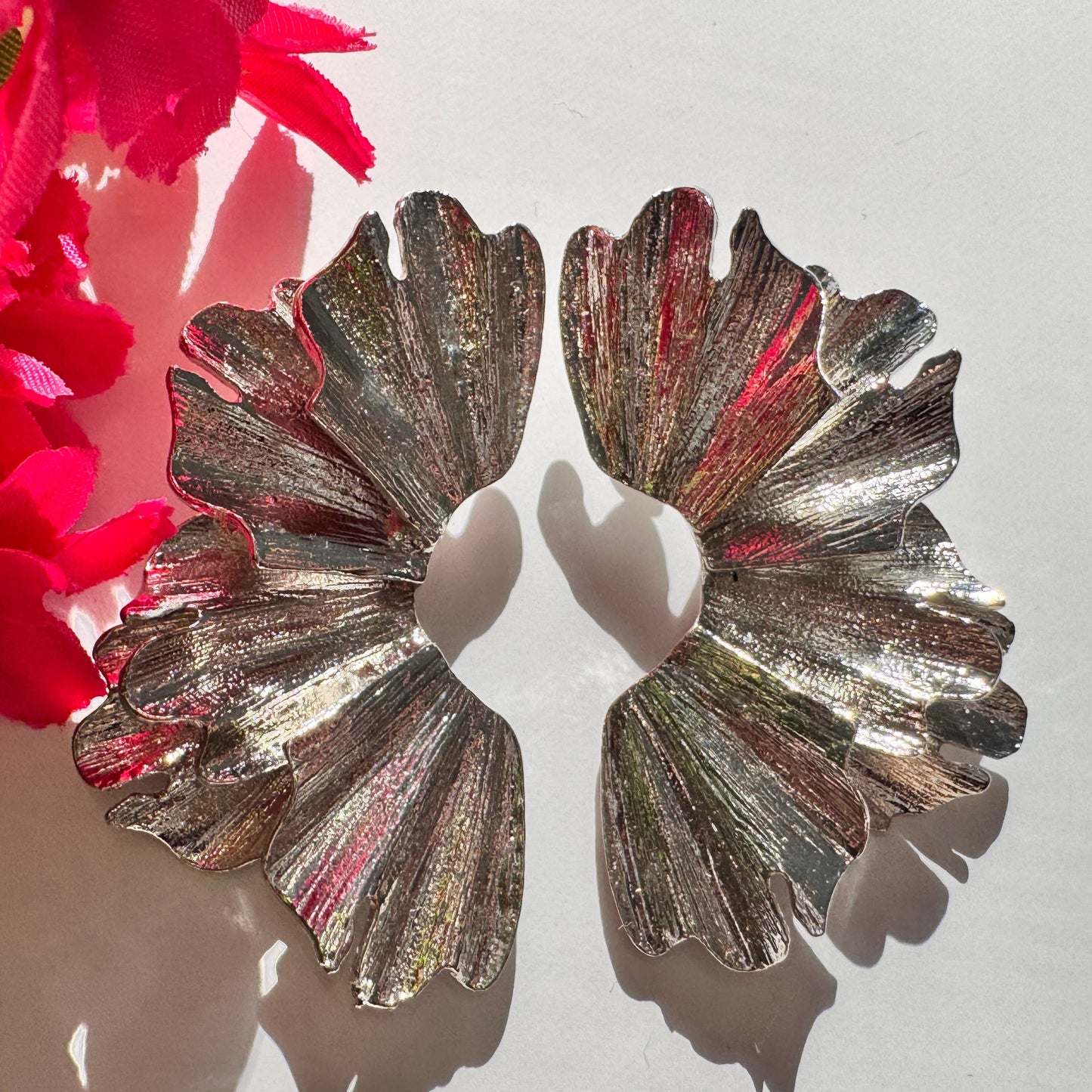 A true statement of elegance and bold sophistication. Crafted with a luxurious sculpted design, these earrings mimic the organic beauty of delicate wings, available in both radiant gold and striking silver finishes. Unique, asymmetric form and high-polish texture create a mesmerizing play of light, making them the perfect accessory to elevate any outfit. 