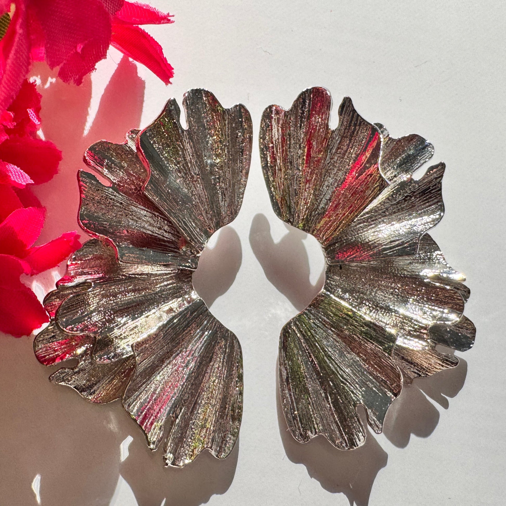  A true statement of elegance and bold sophistication. Crafted with a luxurious sculpted design, these earrings mimic the organic beauty of delicate wings, available in both radiant gold and striking silver finishes. Unique, asymmetric form and high-polish texture create a mesmerizing play of light, making them the perfect accessory to elevate any outfit. 