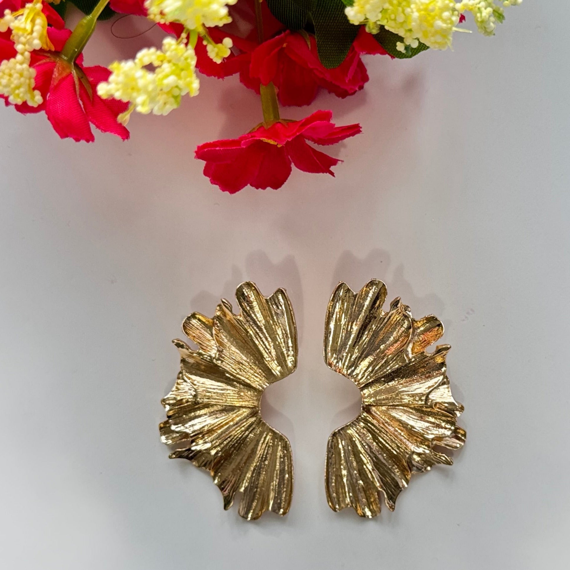 A true statement of elegance and bold sophistication. Crafted with a luxurious sculpted design, these earrings mimic the organic beauty of delicate wings, available in both radiant gold and striking silver finishes. Unique, asymmetric form and high-polish texture create a mesmerizing play of light, making them the perfect accessory to elevate any outfit. 