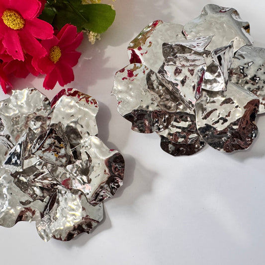 Dare to dazzle with these&nbsp;stunning Hammered Silver Floral Statement Earrings, a true showstopper for modern fashionistas! Crafted with a sculptural, textured metallic finish, these oversized floral earrings radiate contemporary glamour with an artistic edge