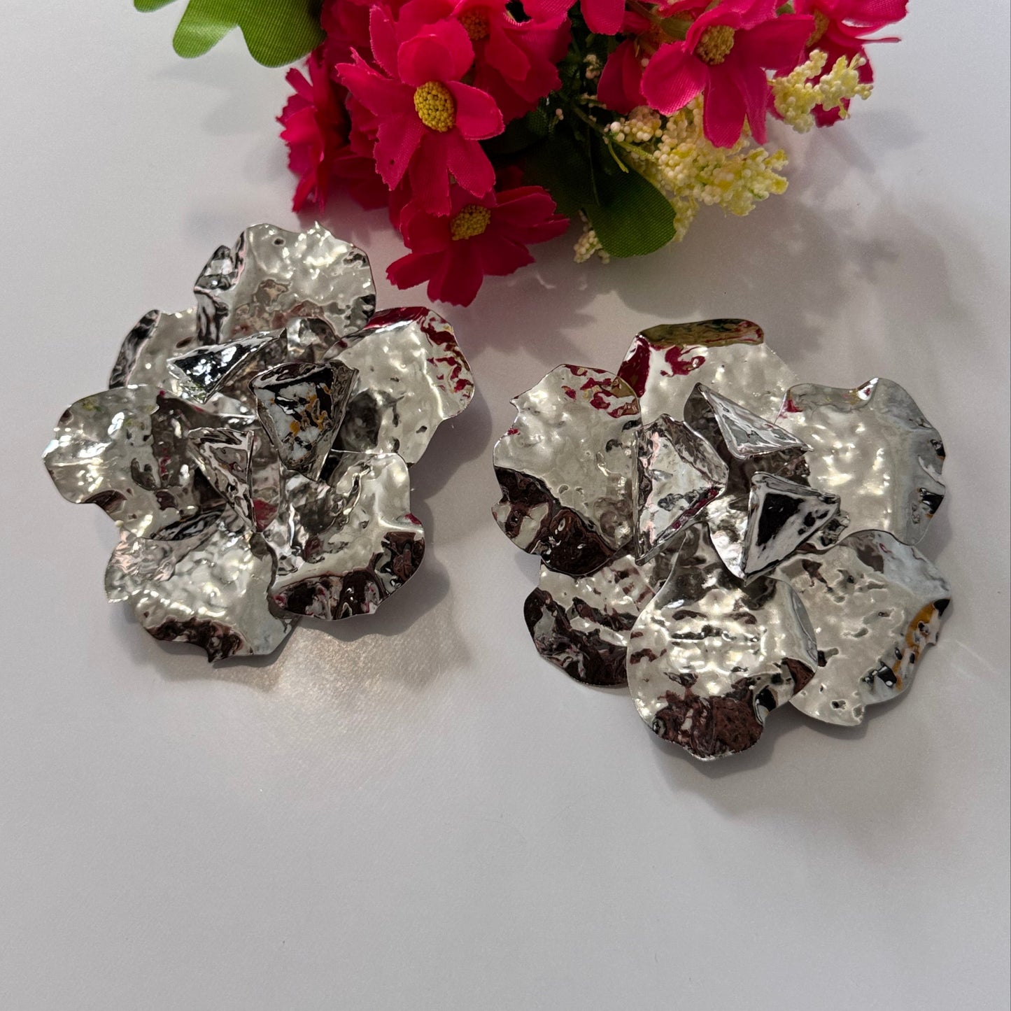 Dare to dazzle with these&nbsp;stunning Hammered Silver Floral Statement Earrings, a true showstopper for modern fashionistas! Crafted with a sculptural, textured metallic finish, these oversized floral earrings radiate contemporary glamour with an artistic edge