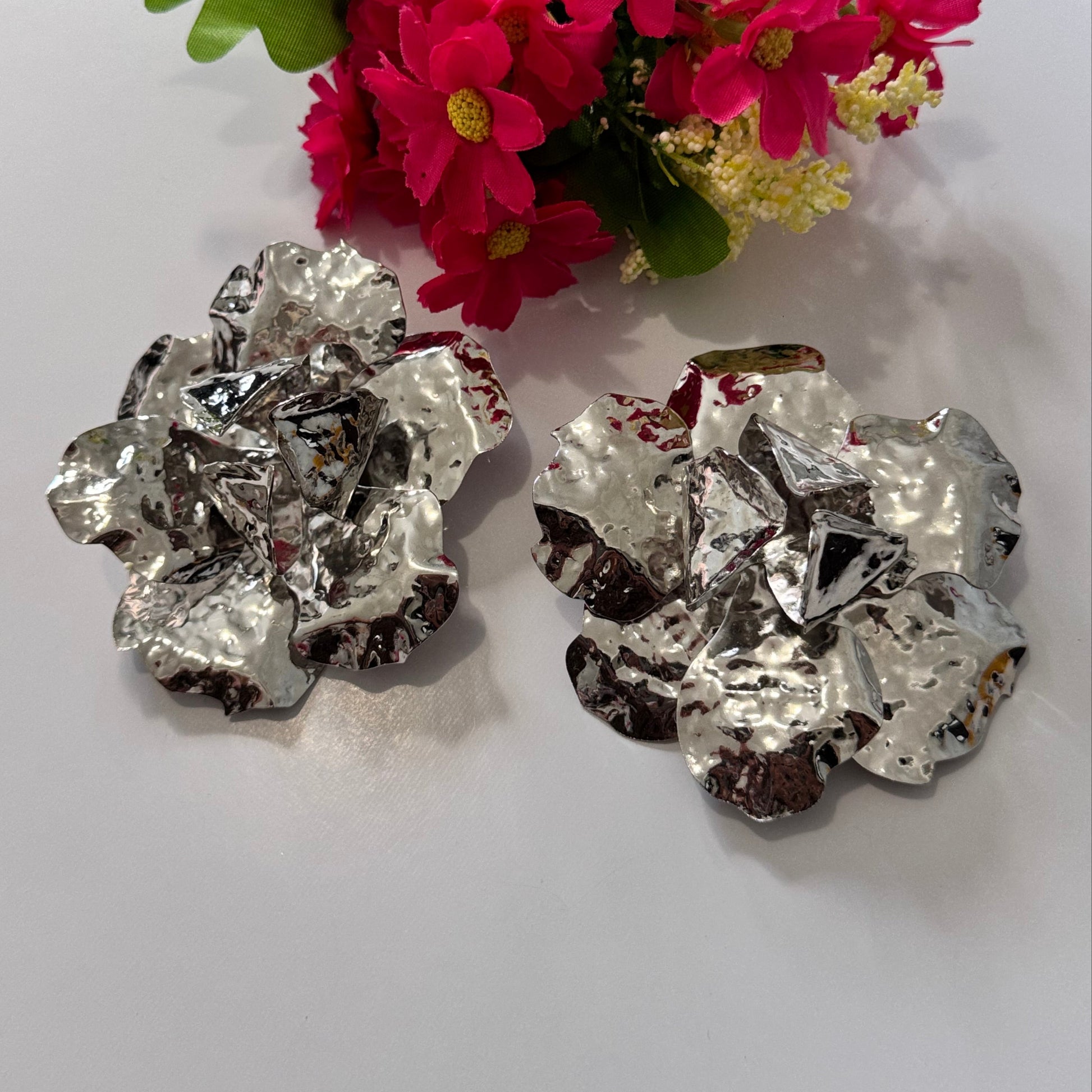 Dare to dazzle with these&nbsp;stunning Hammered Silver Floral Statement Earrings, a true showstopper for modern fashionistas! Crafted with a sculptural, textured metallic finish, these oversized floral earrings radiate contemporary glamour with an artistic edge