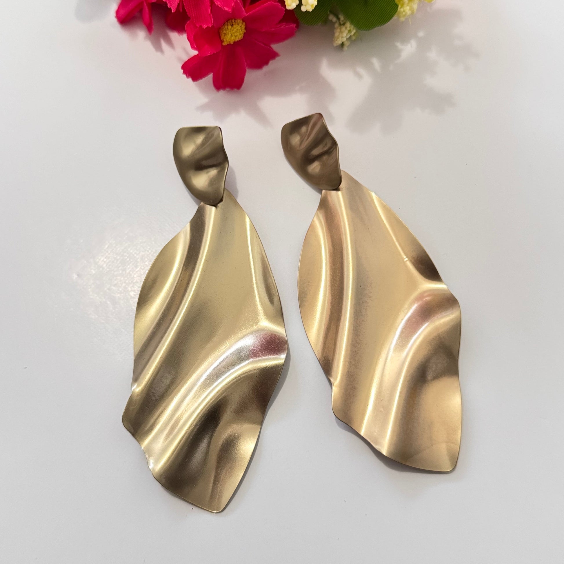 Elevate your style with these stunning gold-tone abstract earrings, designed for those who love modern elegance with a touch of artistic flair. Featuring a fluid, sculptural design that mimics the graceful movement of flowing fabric, these lightweight statement pieces exude sophistication and contemporary charm.