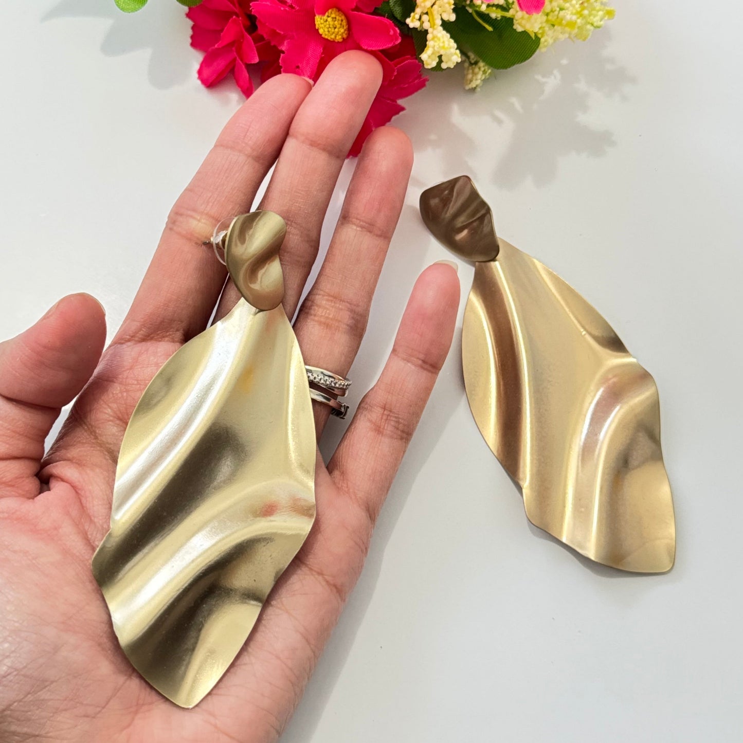 Elevate your style with these stunning gold-tone abstract earrings, designed for those who love modern elegance with a touch of artistic flair. Featuring a fluid, sculptural design that mimics the graceful movement of flowing fabric, these lightweight statement pieces exude sophistication and contemporary charm.