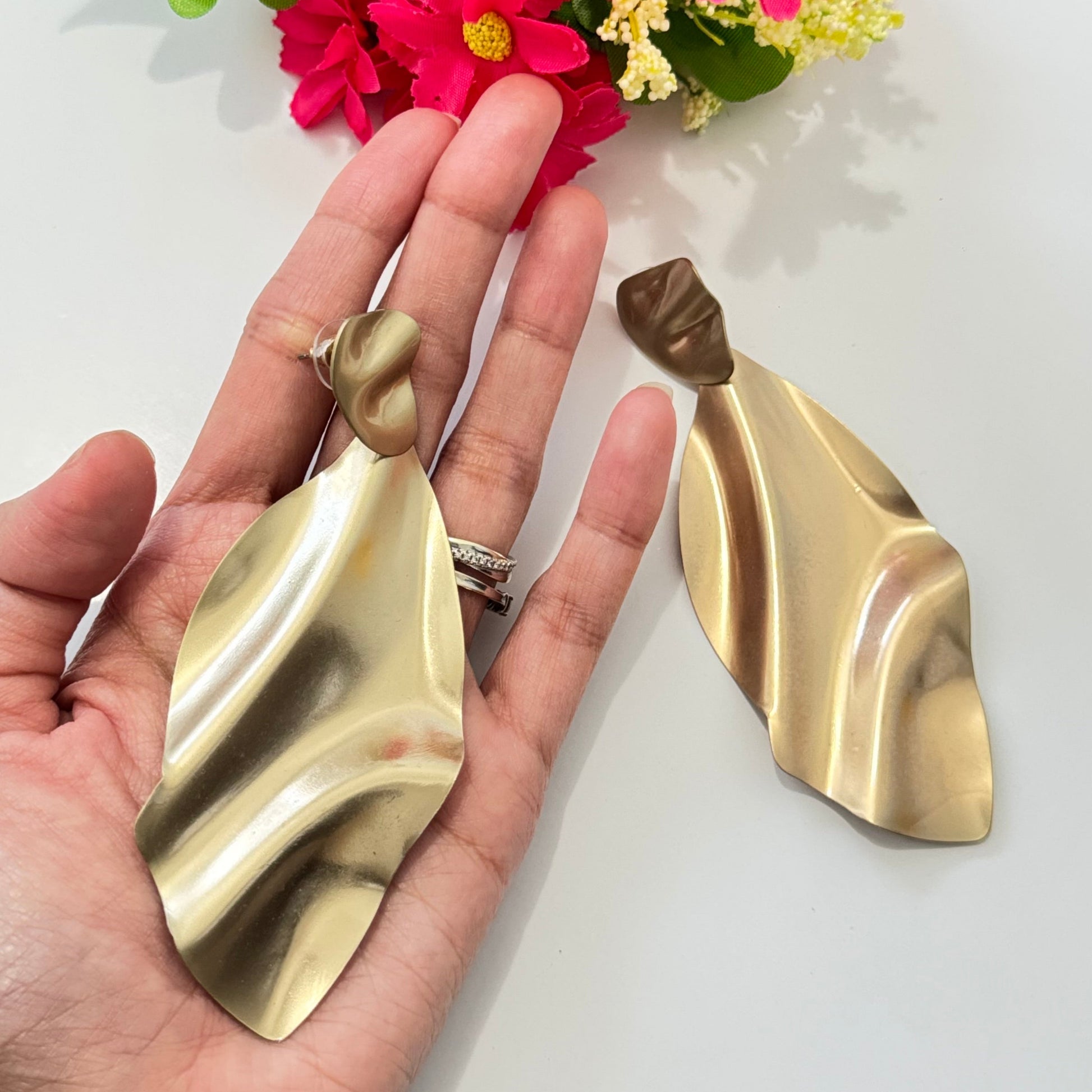 Elevate your style with these stunning gold-tone abstract earrings, designed for those who love modern elegance with a touch of artistic flair. Featuring a fluid, sculptural design that mimics the graceful movement of flowing fabric, these lightweight statement pieces exude sophistication and contemporary charm.