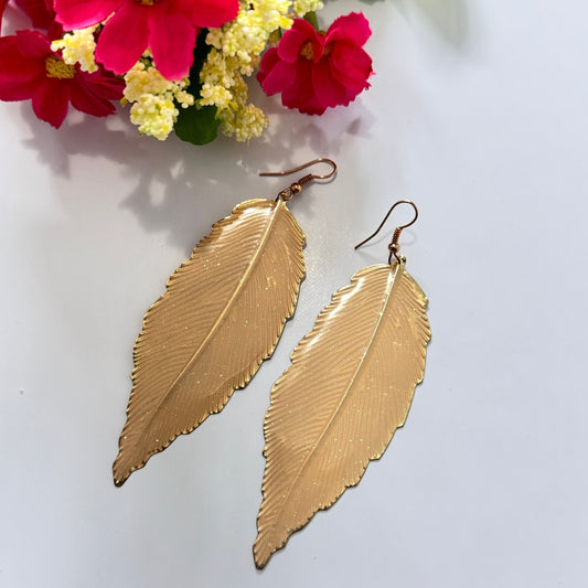 Make a bold yet graceful statement with these stunning Golden Feather Leaf Earrings, designed for those who love the perfect blend of bohemian charm and modern sophistication. Featuring an intricately detailed feather leaf design with a high-shine gold finish, these earrings capture the essence of nature’s beauty in an elegant, lightweight form.