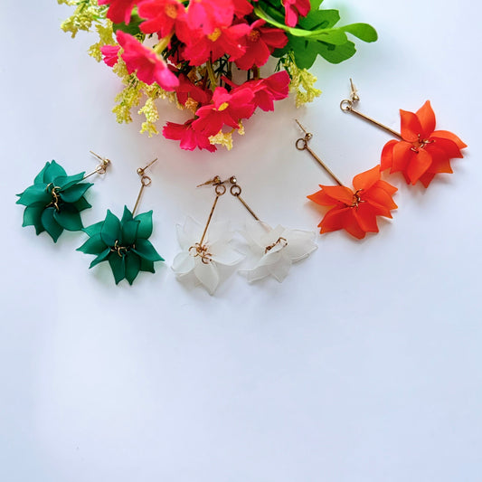 Embrace nature-inspired elegance with these stunning floral drop earrings, designed to add a fresh and feminine touch to any outfit. Featuring delicate, layered petals in rich emerald green, classic white, and vibrant orange, these statement pieces exude charm and sophistication. Suspended from sleek gold-tone accents, they offer a perfect balance of bold color and lightweight comfort. 