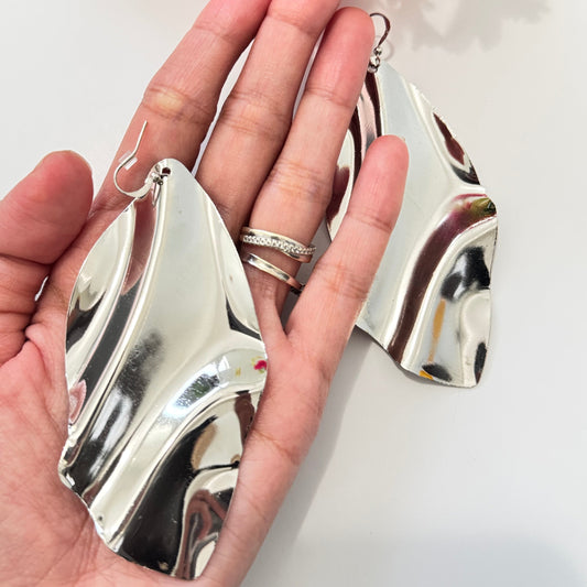 Unleash your bold, artistic side with these stunning wavy metallic statement earrings! Designed for the modern trendsetter, these mirror-finish silver earrings feature a fluid, sculptural form that exudes contemporary elegance and high-fashion appeal.