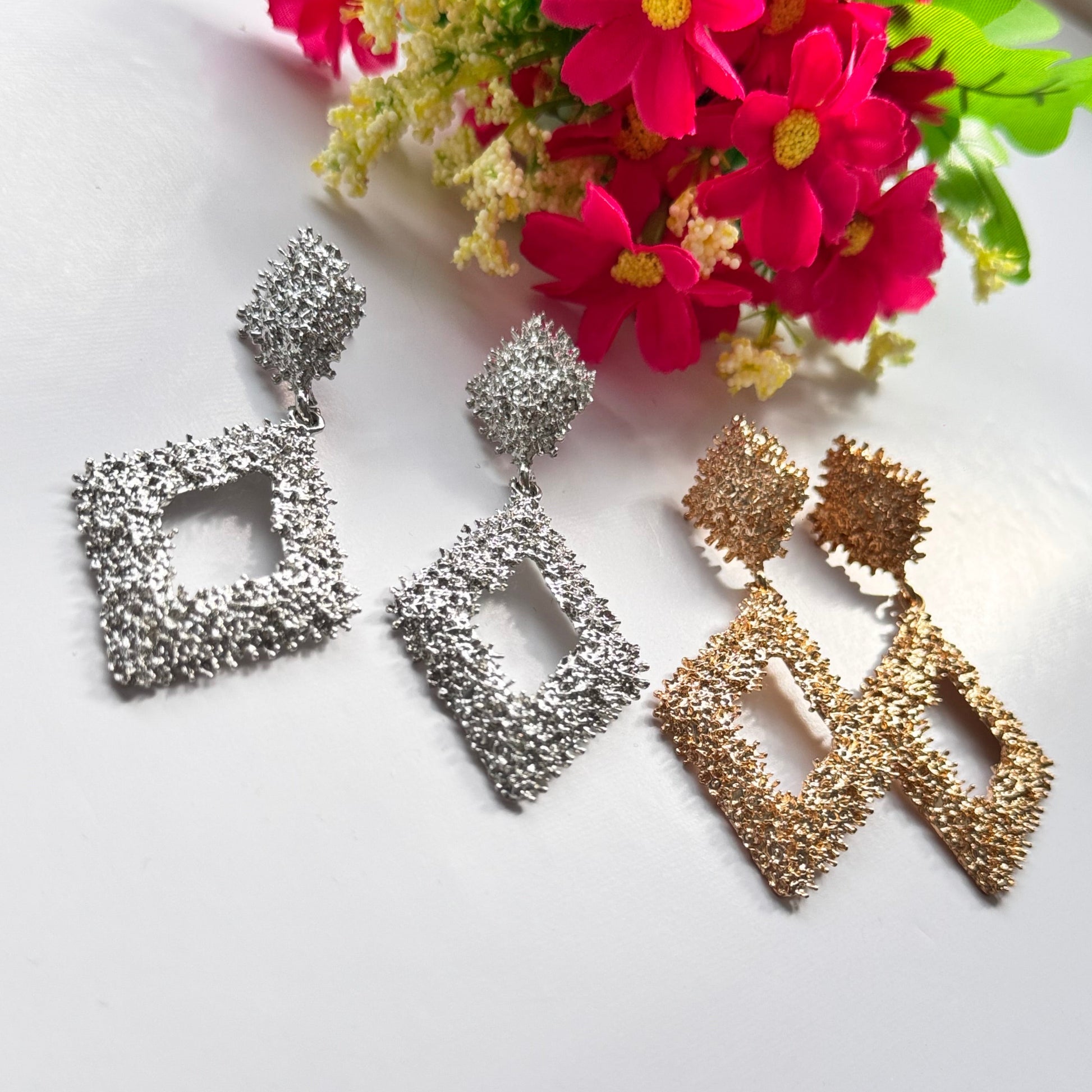 Elevate your style with these dazzling geometric statement earrings, designed to add a touch of elegance and modern sophistication to any outfit. Crafted with a unique textured finish, these bold earrings come in both radiant gold and shimmering silver.