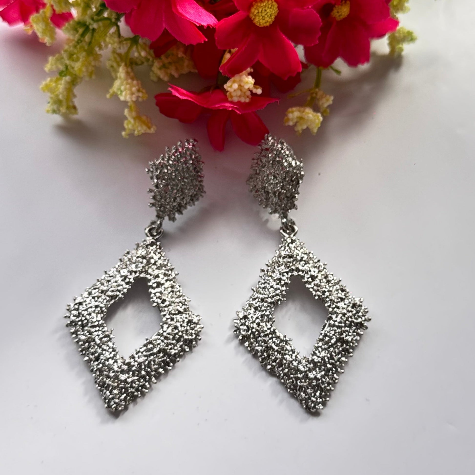 Elevate your style with these dazzling geometric statement earrings, designed to add a touch of elegance and modern sophistication to any outfit. Crafted with a unique textured finish, these bold earrings come in both radiant gold and shimmering silver.