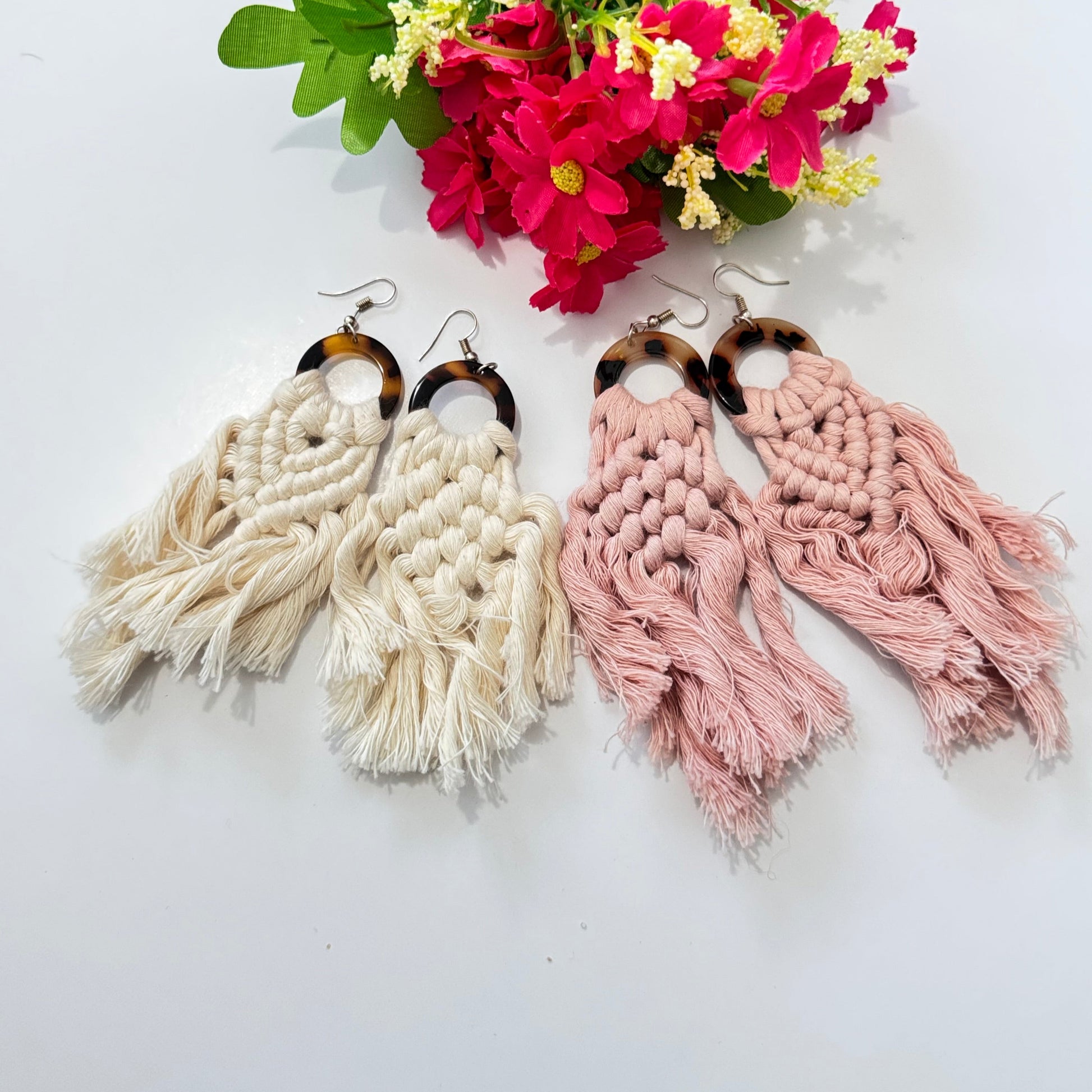 These stunning earrings showcase intricate macramé knotting in soft, natural cream and blush pink hues, complemented by a chic tortoiseshell ring that adds a touch of sophistication. The lightweight, flowy tassels create movement and charm, making these earrings the ultimate statement accessory for any outfit.