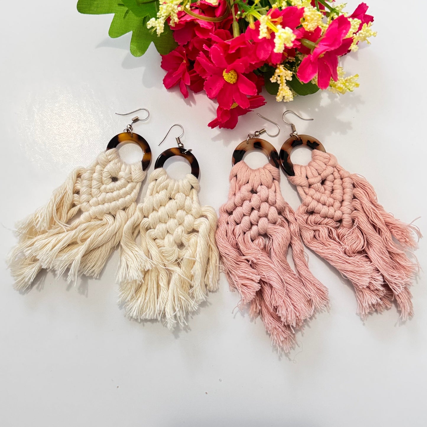 These stunning earrings showcase intricate macramé knotting in soft, natural cream and blush pink hues, complemented by a chic tortoiseshell ring that adds a touch of sophistication. The lightweight, flowy tassels create movement and charm, making these earrings the ultimate statement accessory for any outfit.
