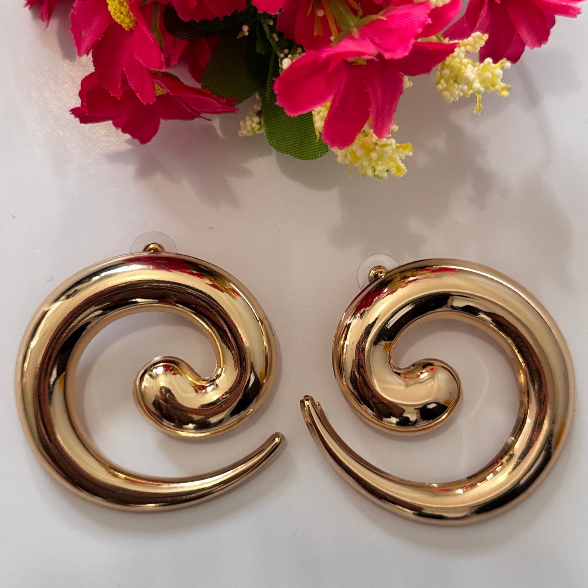 Unleash your inner goddess with these stunning Golden Swirl Statement Earrings, designed to make a lasting impression. Featuring a sleek, spiral silhouette with a high-shine gold finish, these earrings blend modern sophistication with artistic flair. 