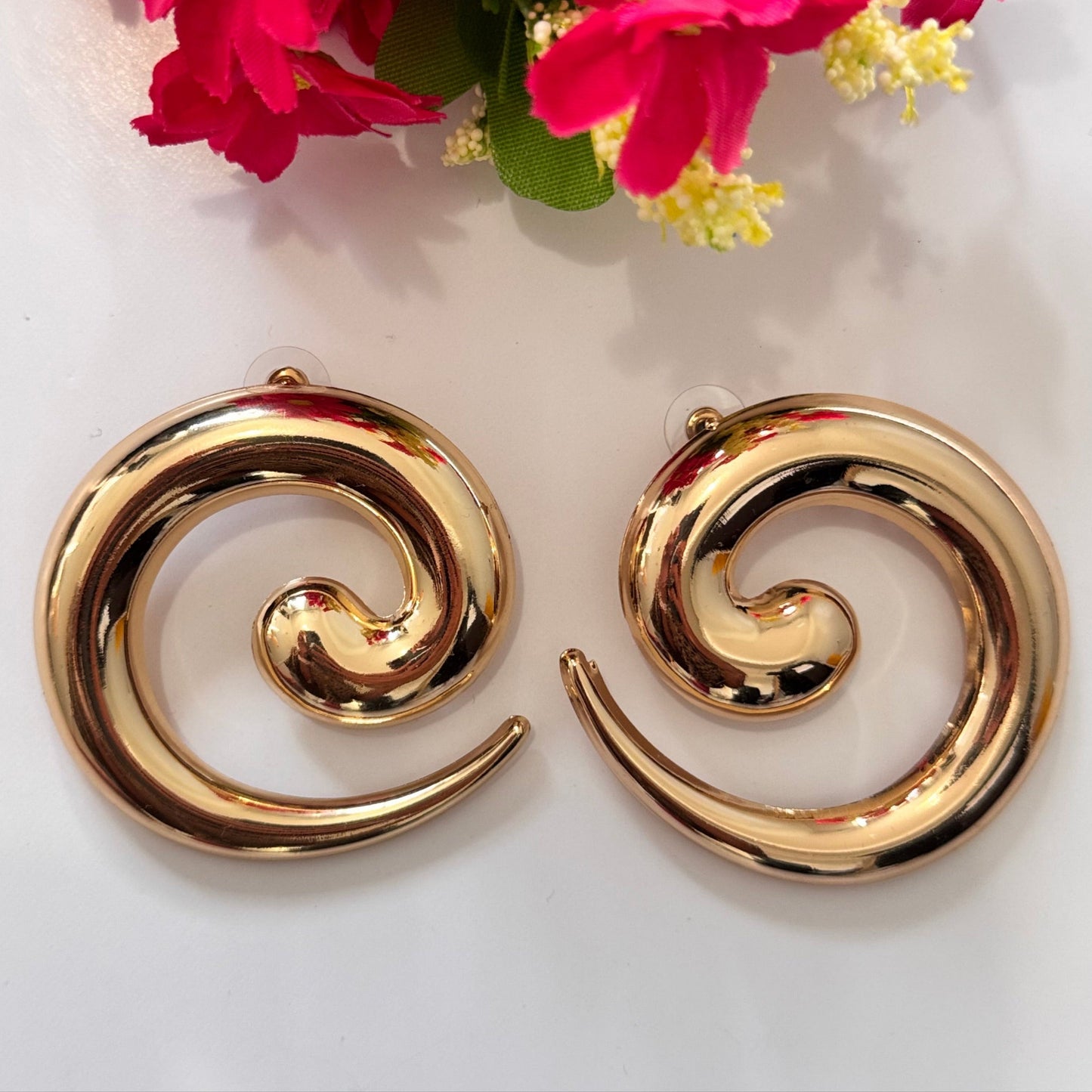 Unleash your inner goddess with these stunning Golden Swirl Statement Earrings, designed to make a lasting impression. Featuring a sleek, spiral silhouette with a high-shine gold finish, these earrings blend modern sophistication with artistic flair. 