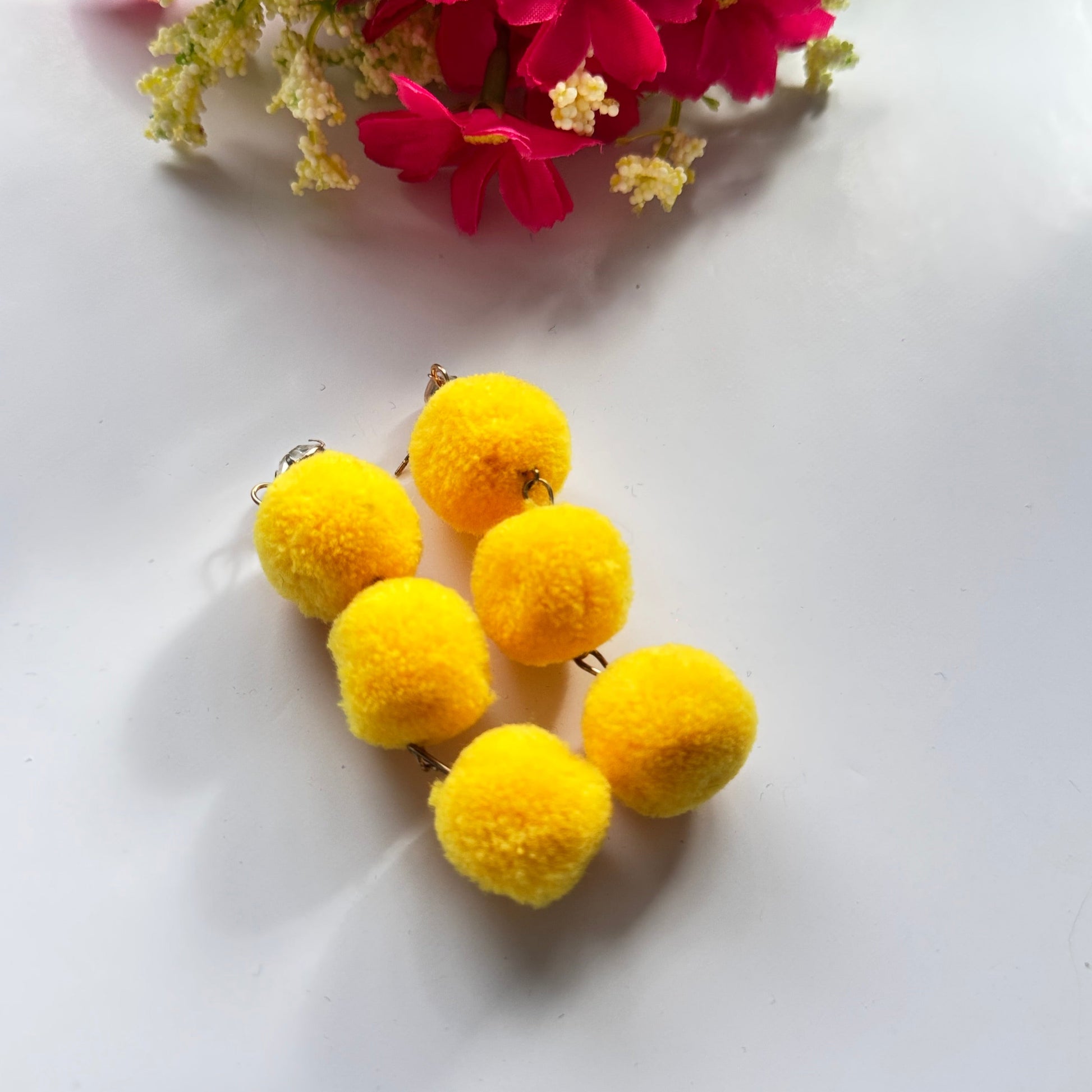 Designed to make a bold statement, these playful yet chic earrings feature three fluffy, lightweight pom-poms stacked elegantly for a dynamic, eye-catching effect. Available in fiery orange, deep royal blue, and radiant sunshine yellow, these earrings bring a fun and energetic touch to any outfit.