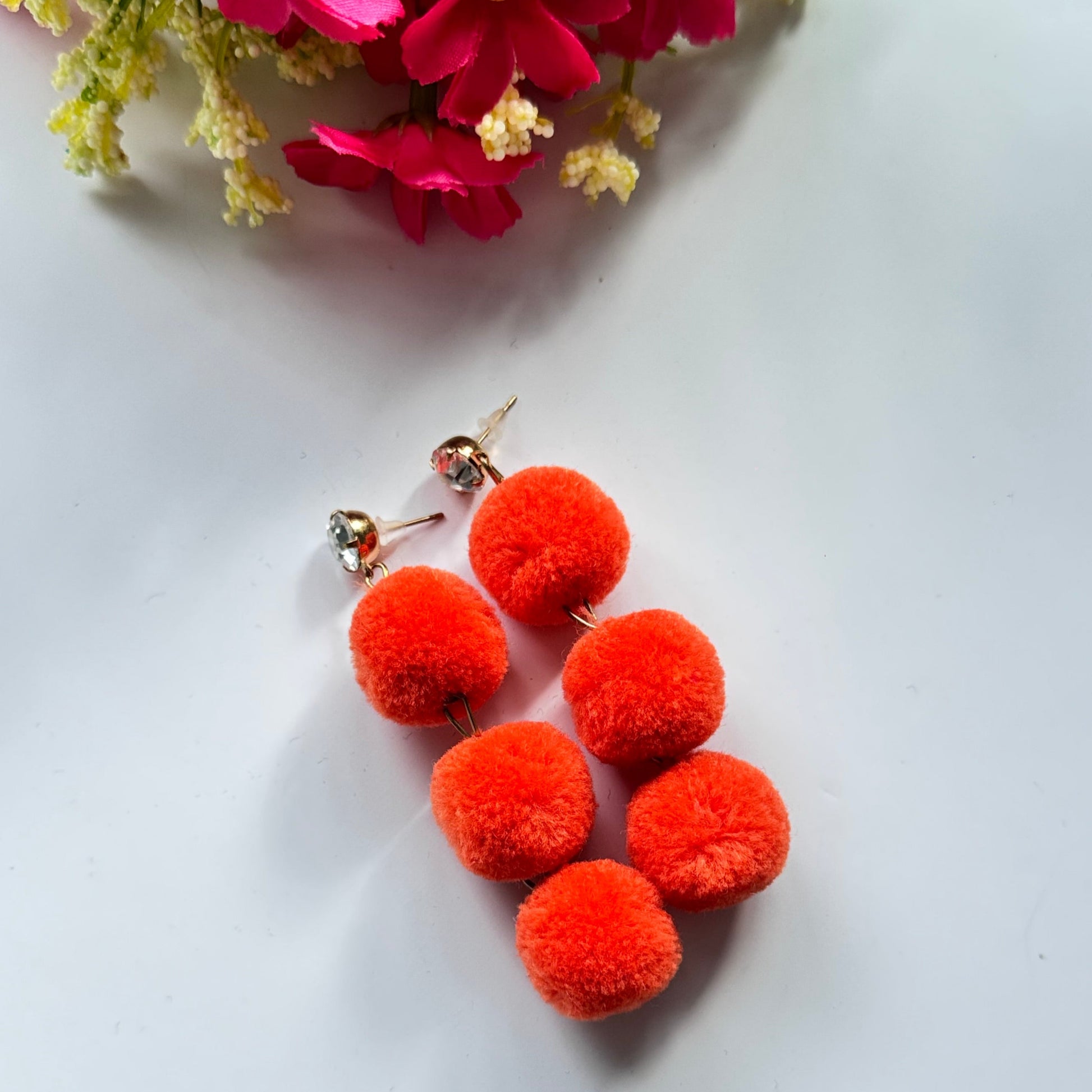 Designed to make a bold statement, these playful yet chic earrings feature three fluffy, lightweight pom-poms stacked elegantly for a dynamic, eye-catching effect. Available in fiery orange, deep royal blue, and radiant sunshine yellow, these earrings bring a fun and energetic touch to any outfit.
