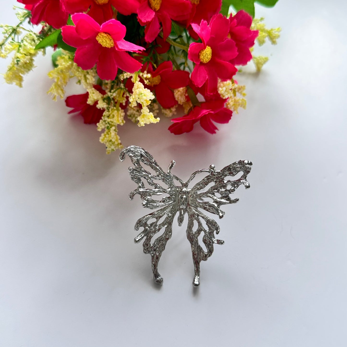 Elevate your style with this breathtaking silver butterfly statement adjustable ring, designed to captivate with its intricate details and bold presence. Crafted with a textured metal finish, this striking piece embodies grace, freedom, and transformation, making it the perfect accessory for those who love to express their individuality.