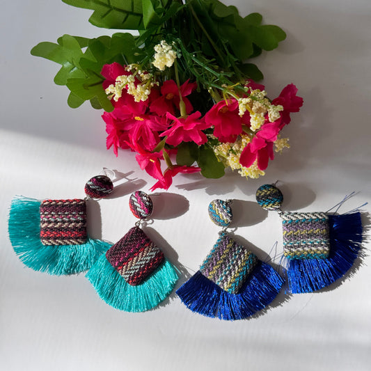These stunning, artisan-crafted statement pieces feature a unique woven textile design, accented with luxurious silky tassels in bold turquoise and royal blue hues. Designed for trendsetters, these earrings blend&nbsp;bohemian elegance with contemporary flair, making them the perfect accessory for festivals, beach vacations, or casual chic outfits. Lightweight yet bold, they are a must-have for fashion lovers who dare to stand out.