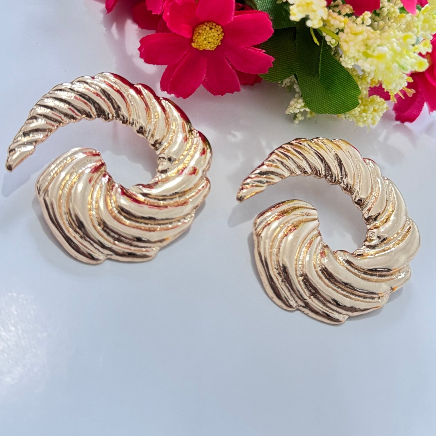 Designed with an elegant twisted spiral shape, these earrings exude classic glamour with a bold, contemporary edge. Their high-polish gold finish reflects light beautifully, making them the perfect statement piece for any occasion.