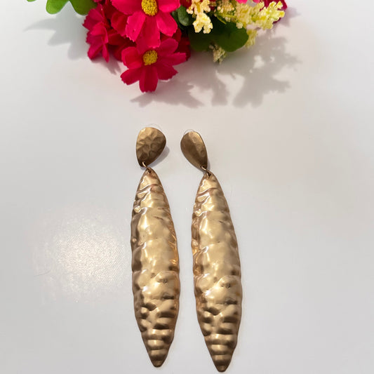 Elevate your style with these striking hammered gold statement earrings, designed to captivate and command attention. This elongated silhouette and textured finish create a stunning interplay of light and shadow, ensuring it shimmer with every movement.