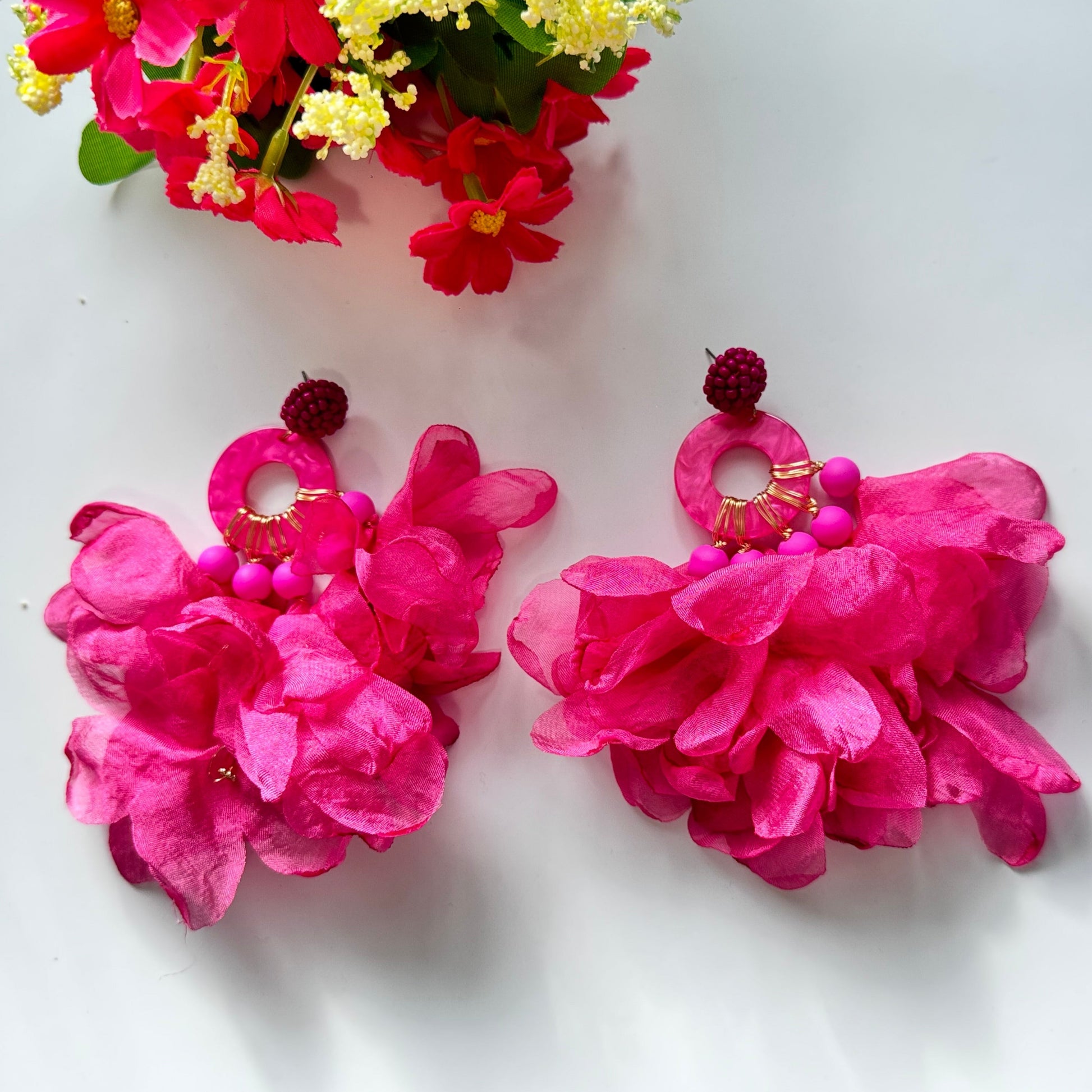 Unleash your inner diva with these stunning hot pink floral statement earrings, designed to turn heads and make every outfit pop! Featuring voluminous chiffon petals, gold-tone accents, and beaded details, these oversized earrings are the perfect mix of elegance and boldness. 