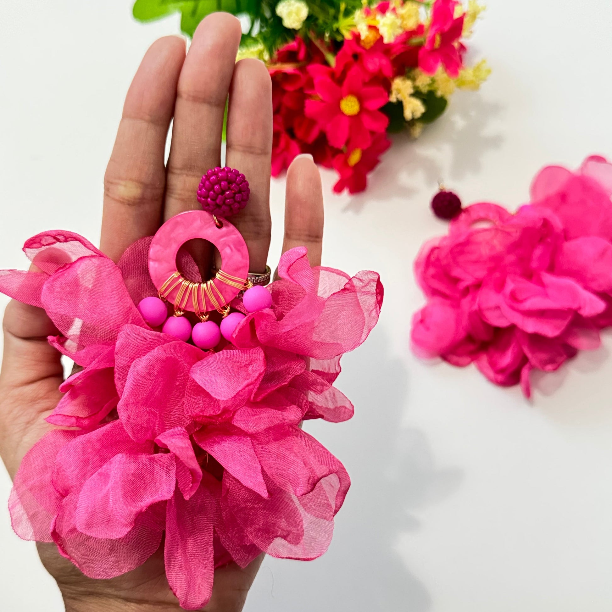 Unleash your inner diva with these stunning hot pink floral statement earrings, designed to turn heads and make every outfit pop! Featuring voluminous chiffon petals, gold-tone accents, and beaded details, these oversized earrings are the perfect mix of elegance and boldness. 