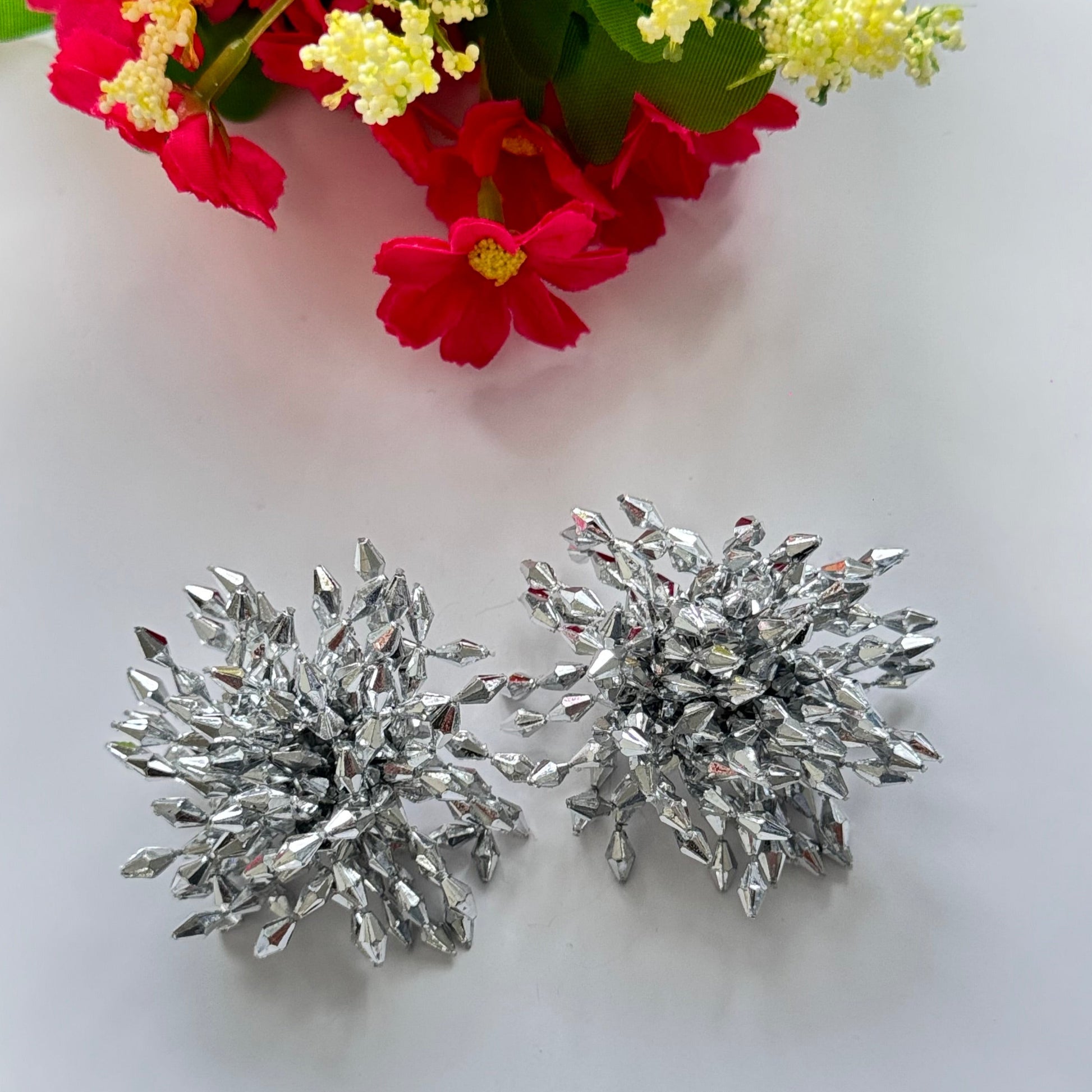 Introducing our Dazzling Crystal Burst Earrings – the epitome of elegance and bold glamour!These statement earrings feature a striking explosion of silver-toned crystals, intricately arranged to reflect light from every angle.