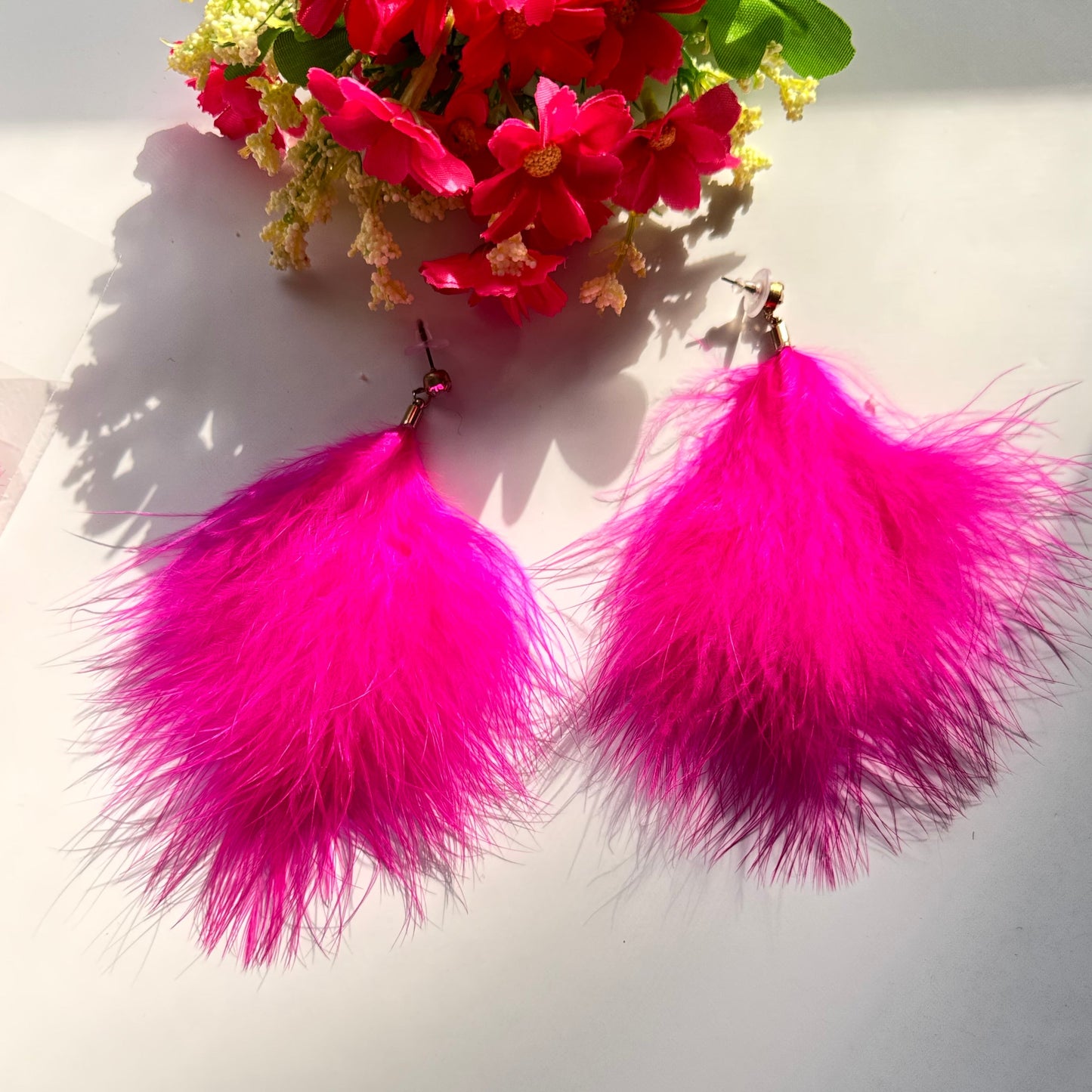 Turn heads and make a bold statement with these ultra-glamorous, hot pink feather earrings that redefine elegance with a touch of playful extravagance. Designed to add drama to any outfit, these lightweight, fluffy masterpieces sway effortlessly with every movement, catching the light and drawing attention wherever you go. The vibrant fuchsia hue radiates confidence, passion, and undeniable charm, making them the perfect choice for trendsetters who love to stand out.