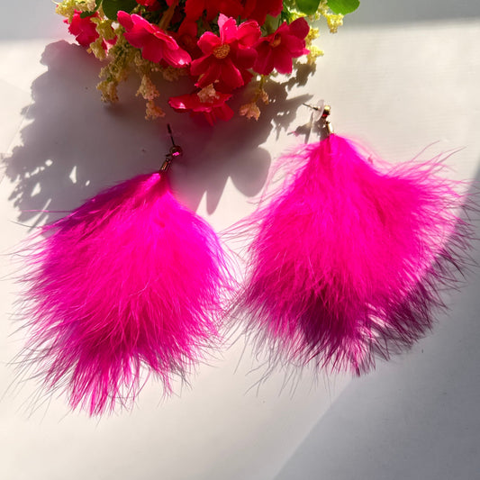 Turn heads and make a bold statement with these ultra-glamorous, hot pink feather earrings that redefine elegance with a touch of playful extravagance. Designed to add drama to any outfit, these lightweight, fluffy masterpieces sway effortlessly with every movement, catching the light and drawing attention wherever you go. The vibrant fuchsia hue radiates confidence, passion, and undeniable charm, making them the perfect choice for trendsetters who love to stand out.