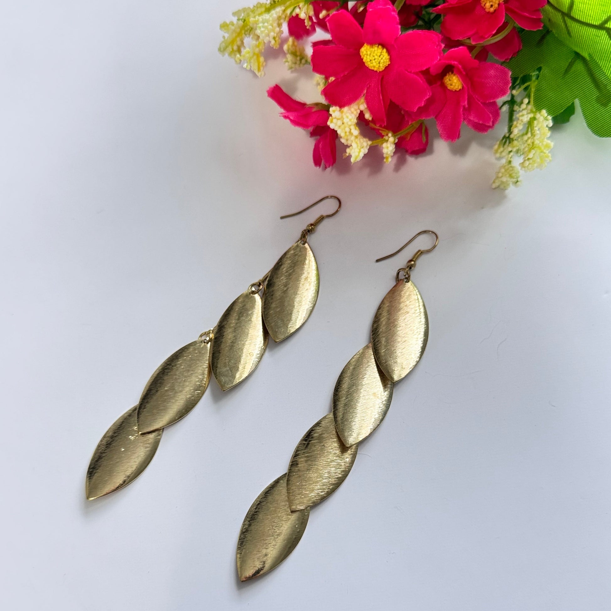 Elevate your style with these stunning gold-tone cascading leaf earrings, a perfect blend of elegance and sophistication. Designed with a sleek, brushed-metal finish, each delicate leaf dangles gracefully, creating a mesmerizing movement that catches the light with every step.