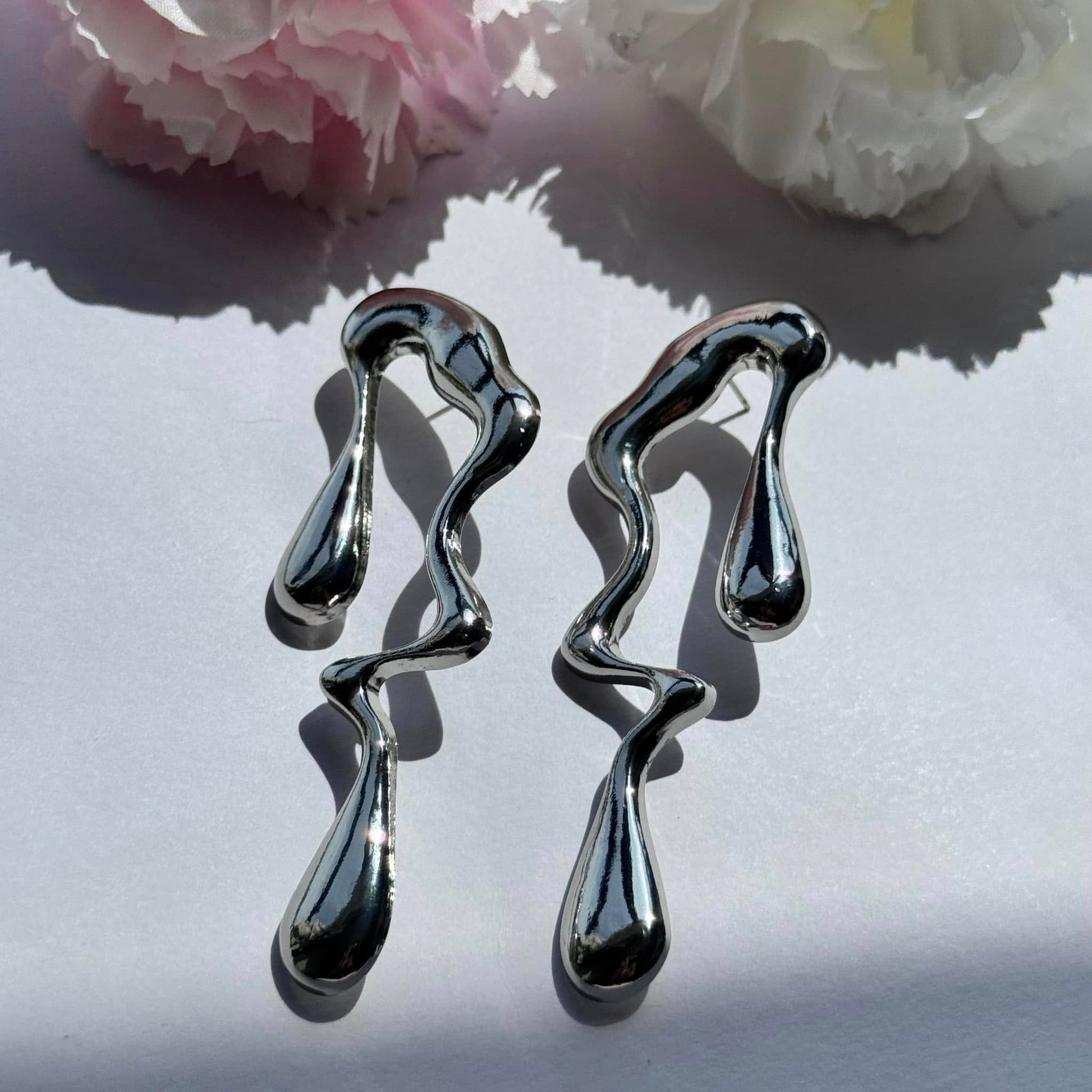 Sculptural earrings with a mesmerizing molten drip design—bold, artistic, and effortlessly chic. Perfect for making a statement!

Brand new
Available in silver and gold