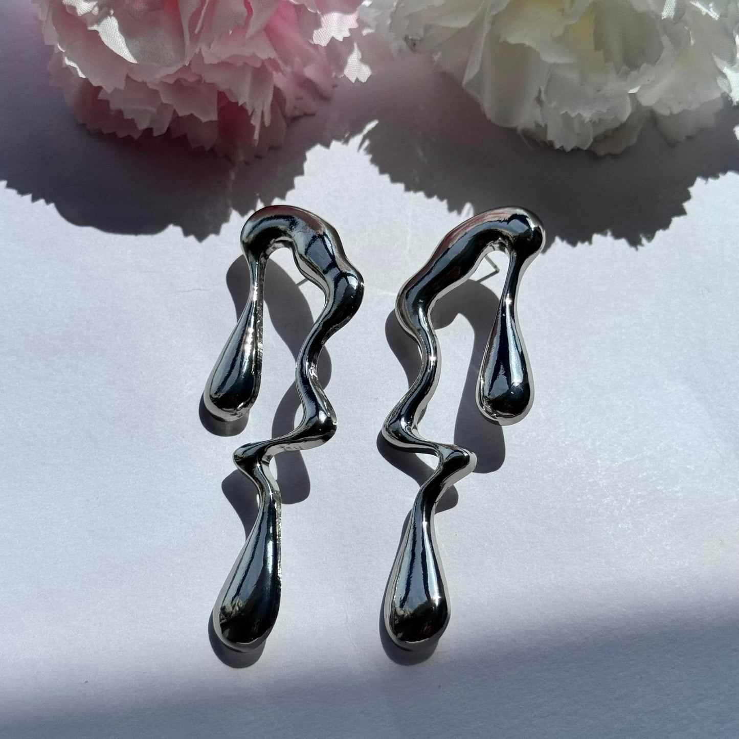 Sculptural earrings with a mesmerizing molten drip design—bold, artistic, and effortlessly chic. Perfect for making a statement!

Brand new
Available in silver and gold