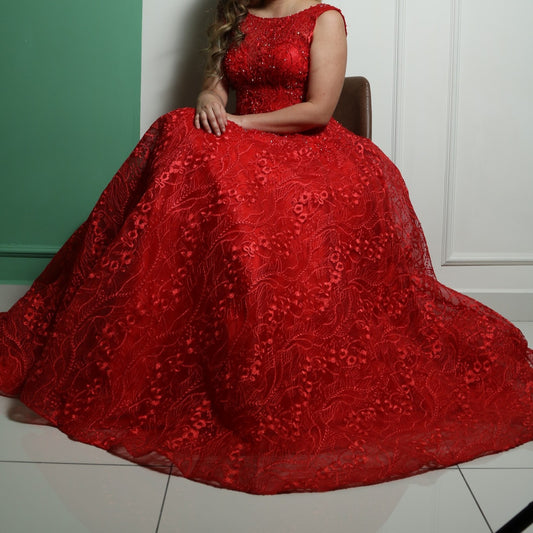 This dress is an elegant, floor-length red gown with intricate lace and beaded detailing. The design features a fitted bodice with cap sleeves and a voluminous skirt, creating a regal and dramatic silhouette. The heavy fabric and detailed embellishments add to its luxurious feel, making it suitable for formal events such as galas or weddings.