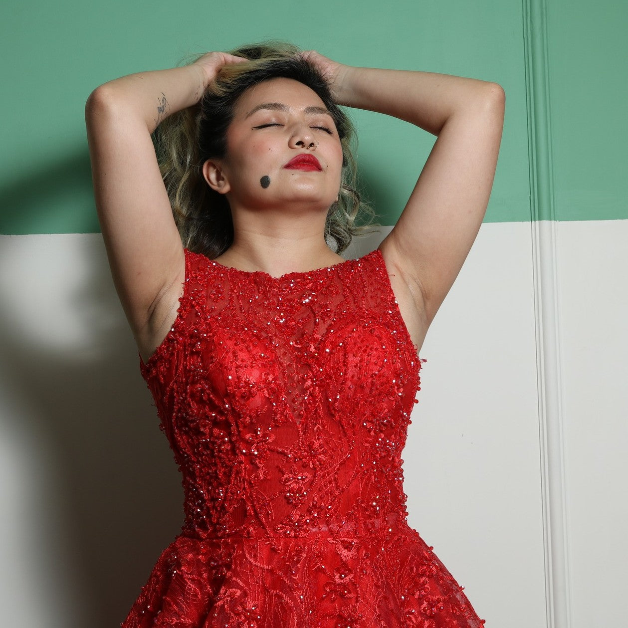 This dress is an elegant, floor-length red gown with intricate lace and beaded detailing. The design features a fitted bodice with cap sleeves and a voluminous skirt, creating a regal and dramatic silhouette. The heavy fabric and detailed embellishments add to its luxurious feel, making it suitable for formal events such as galas or weddings.
