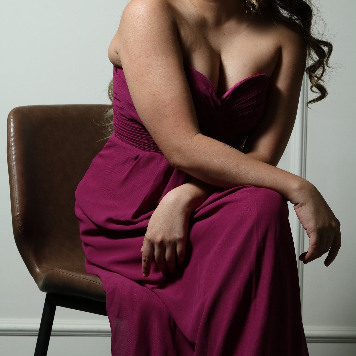 This elegant strapless gown features a beautifully ruched bodice and a flowing A-line skirt, creating a timeless and flattering silhouette. The rich magenta color adds a bold and sophisticated touch, perfect for formal events, bridesmaids, or special occasions. Crafted from lightweight fabric, it offers both comfort and style for an effortlessly graceful look.