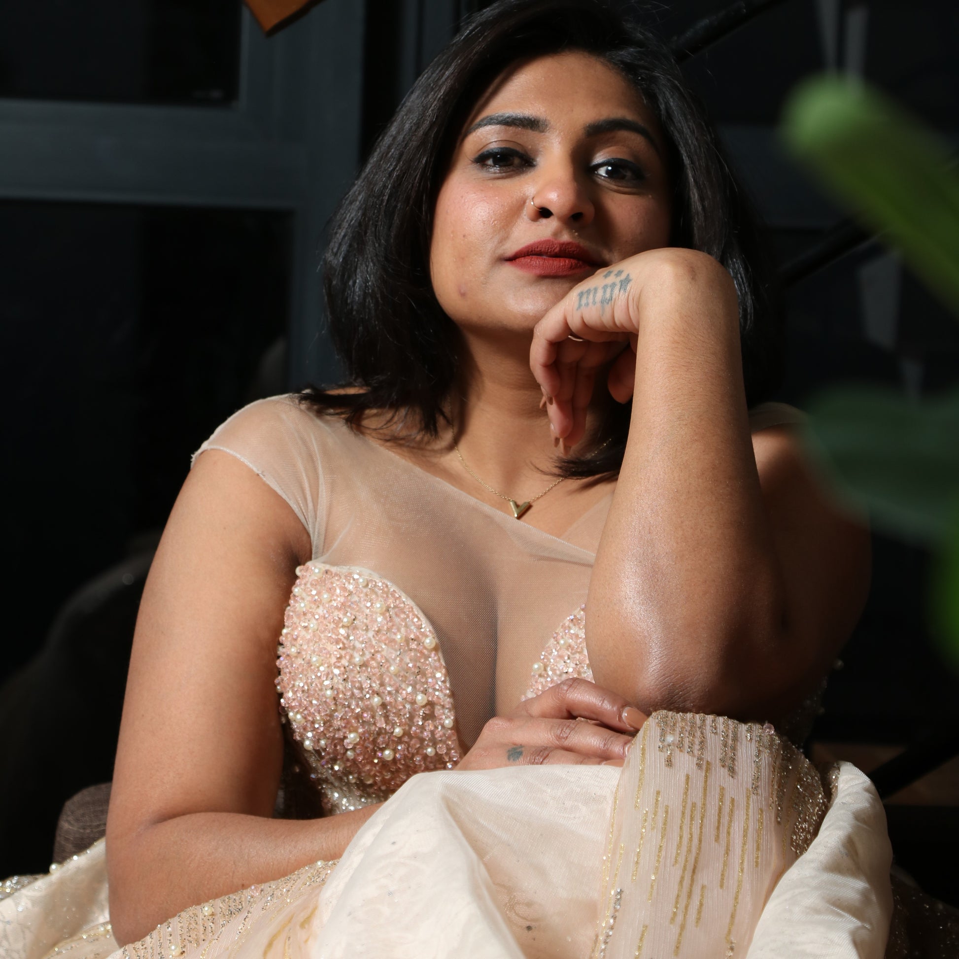 The dress in the image is an elegant, heavily embellished gown with a fitted bodice and a voluminous skirt. It features intricate beadwork and embroidery, giving it a luxurious and opulent look. The sheer illusion neckline adds a delicate touch, while the structured, corset-like bodice enhances the silhouette. The fabric appears to be thick and richly adorned, making the dress quite heavy. The overall design exudes a regal and glamorous feel, perfect for a formal event or gala.