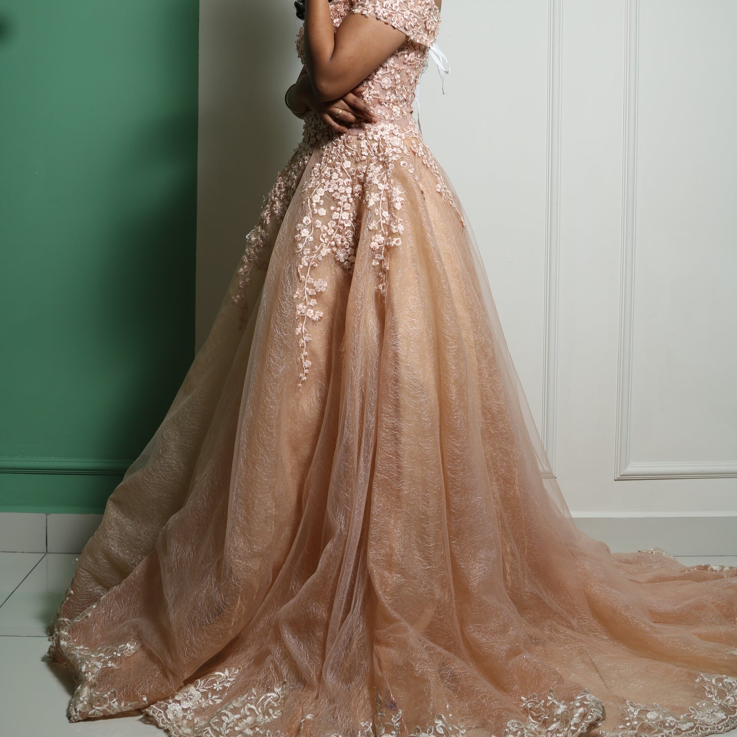 This exquisite gown exudes grace and sophistication with its intricate floral embroidery and delicate lace appliqués. The soft peach hue complements the voluminous layers of fabric, creating a regal and ethereal silhouette. The sheer detailing on the bodice adds a touch of elegance, while the heavy structure of the dress enhances its grandeur. Perfect for a gala, wedding, or any formal affair, this masterpiece is a true blend of luxury and artistry.