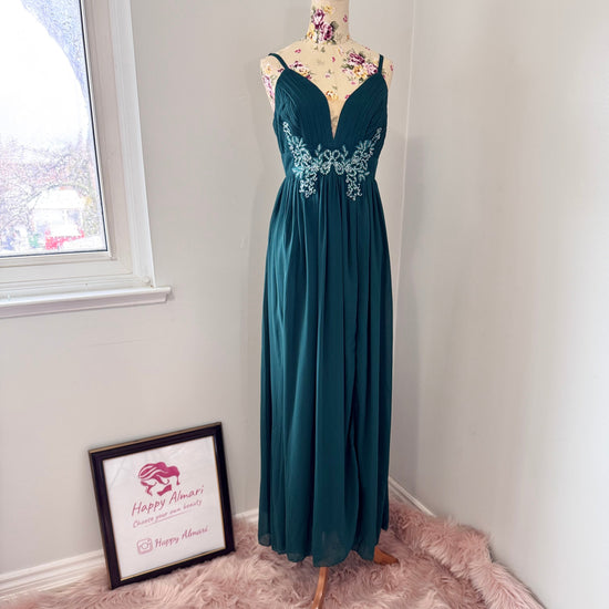 Elevate your evening look with this breathtaking emerald green gown, designed to make a statement at any formal occasion. Featuring a figure-flattering silhouette with a pleated bodice, delicate spaghetti straps, and a plunging neckline, this dress exudes effortless elegance. The intricate floral embellishments at the waist add a touch of romance, while the flowing chiffon skirt ensures graceful movement with every step.