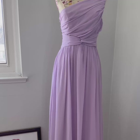 Turn heads in this breathtaking one-shoulder lavender gown, designed to make a statement at weddings, proms, and special occasions. Crafted with delicate pleated draping, a cinched waist for a flattering silhouette, and an elegant flowing skirt, this dress exudes timeless charm. Its soft, ethereal chiffon fabric creates a dreamy and romantic look.