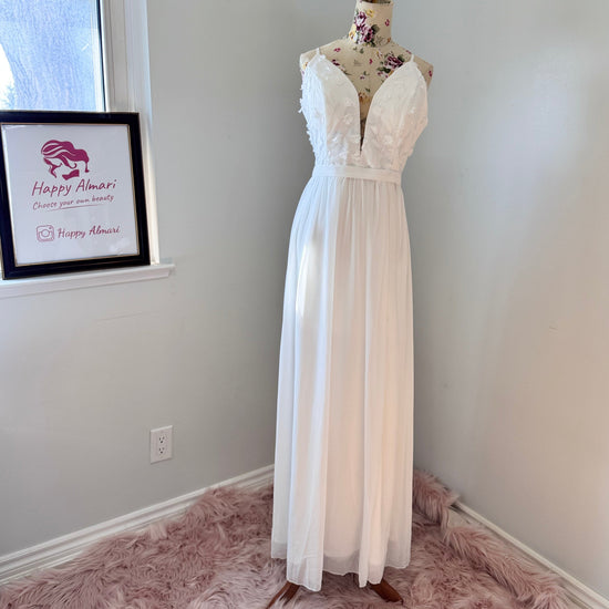 Elevate your style with this breathtaking white gown, designed to captivate with its effortless elegance and timeless charm. Featuring a flowy A-line silhouette, this dress showcases a delicate plunging V-neckline adorned with intricate 3D floral appliqués and embroidered leaf details, adding a soft, ethereal touch. The fitted bodice seamlessly transitions into a lightweight, flowing chiffon skirt, creating graceful movement with every step.