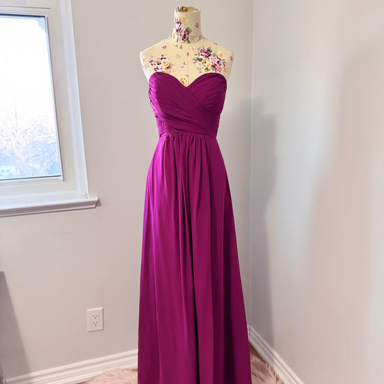 Make a statement in this breathtaking pre-owned, pristine-condition magenta gown, designed to turn heads at any formal event. Featuring a timeless sweetheart neckline with elegant ruched detailing, this floor-length dress flows effortlessly, creating a stunning silhouette that flatters every figure. The flowy chiffon fabric adds a touch of romance, perfect for weddings, galas, proms, or evening soirées. 