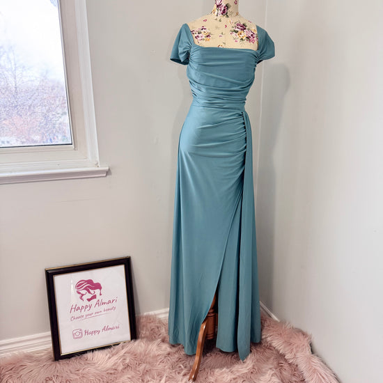 Turn heads with this stunning ocean-blue draped evening gown, designed to flatter every curve with its elegant ruched bodice and flowing silhouette. Featuring an off-shoulder neckline and a sultry side slit, this dress is perfect for weddings, formal events, and special occasions where making a statement is a must! The smooth, high-quality fabric offers a graceful drape, ensuring you move with confidence and poise.