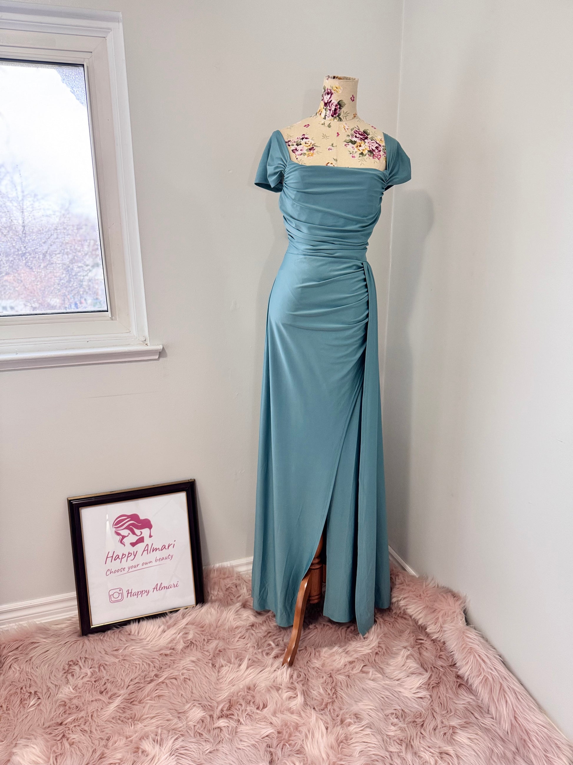 Turn heads with this stunning ocean-blue draped evening gown, designed to flatter every curve with its elegant ruched bodice and flowing silhouette. Featuring an off-shoulder neckline and a sultry side slit, this dress is perfect for weddings, formal events, and special occasions where making a statement is a must! The smooth, high-quality fabric offers a graceful drape, ensuring you move with confidence and poise.