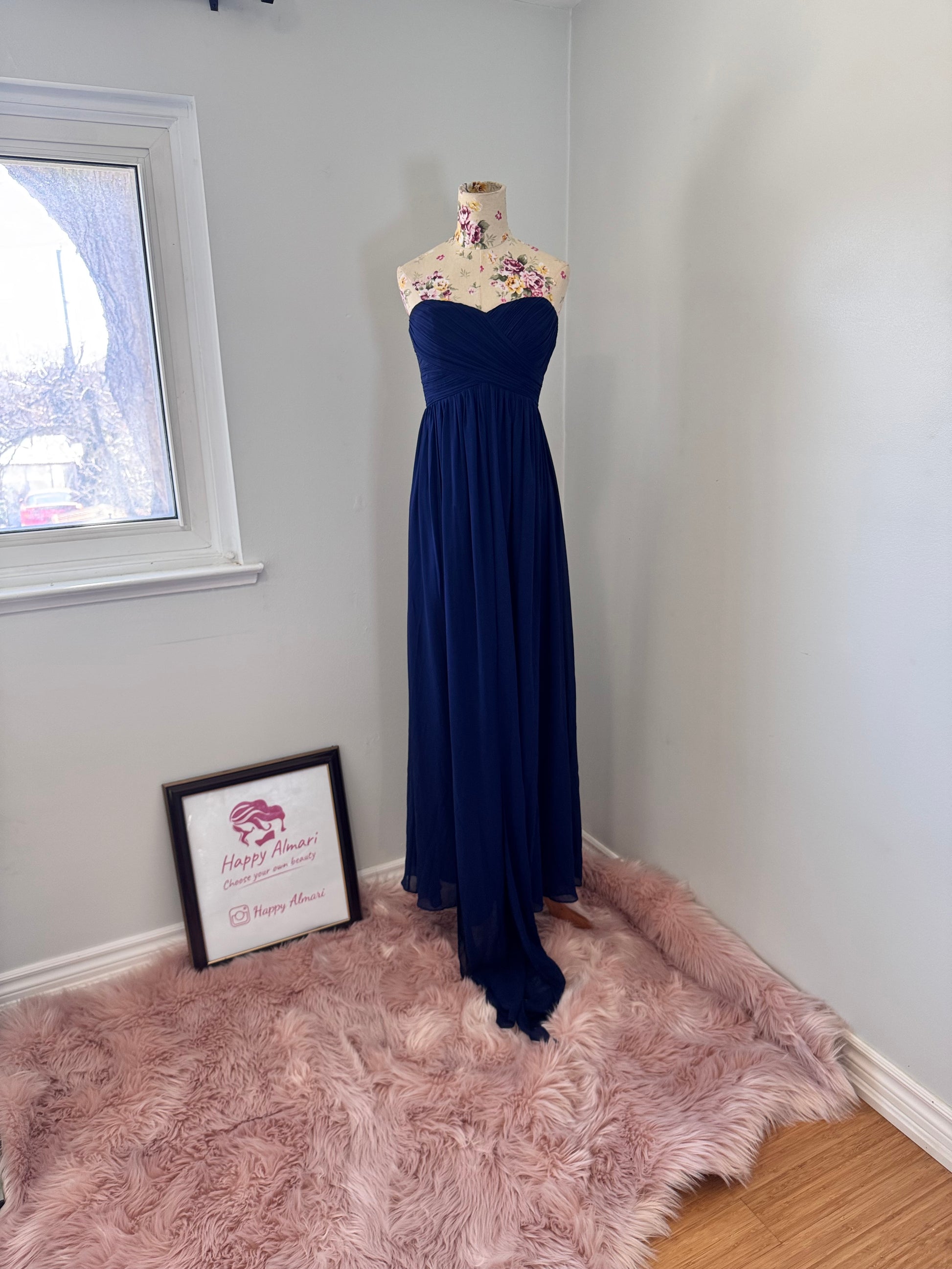 Elevate your elegance with this breathtaking navy-blue strapless evening gown, designed to make a statement at any special occasion. Featuring a flattering sweetheart neckline and a beautifully flowing chiffon skirt with a dramatic floor-length train, this dress exudes timeless sophistication. The structured bodice provides a secure fit, while the soft pleats add a touch of effortless charm. 