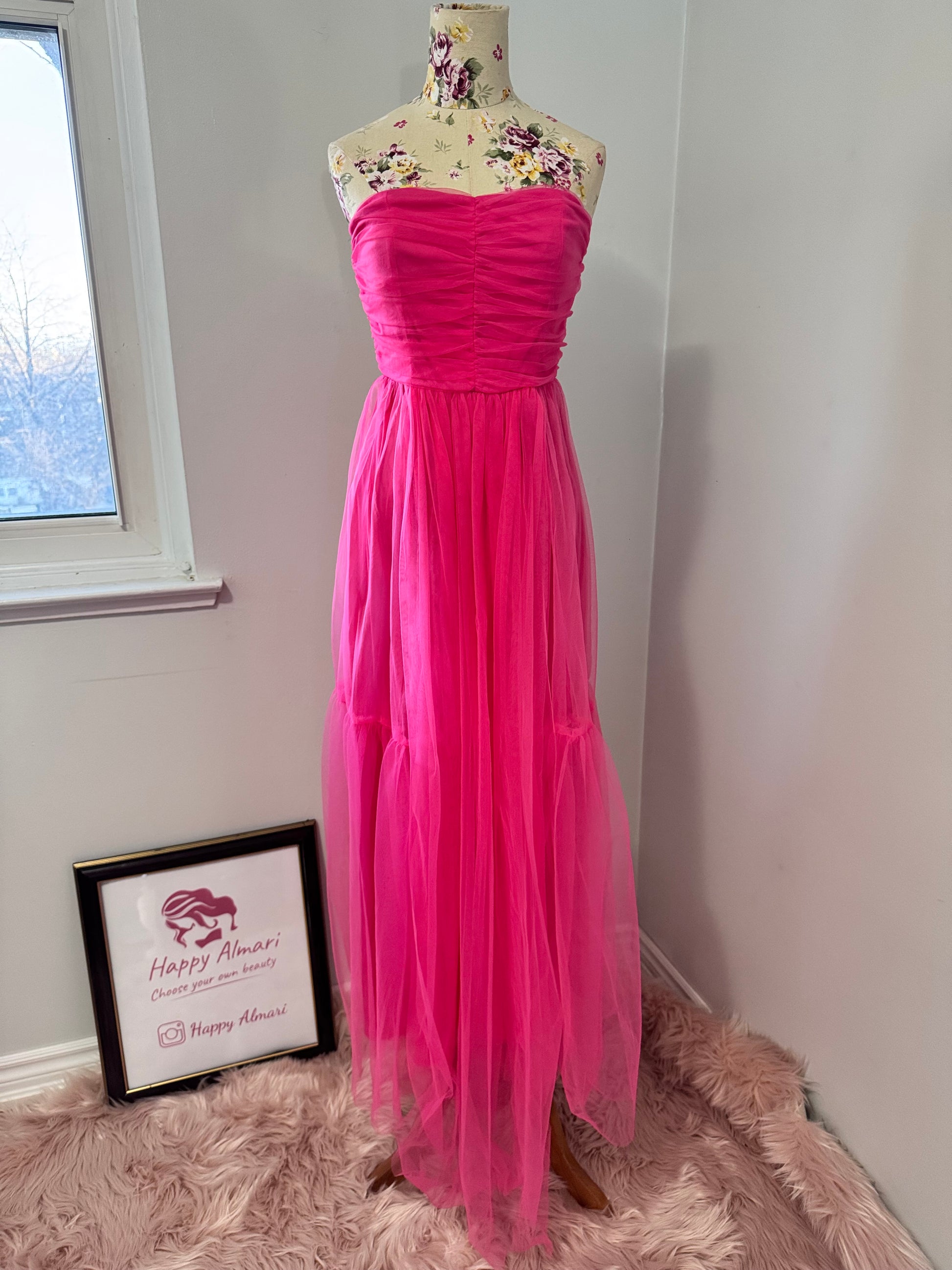 Turn heads and steal the spotlight in this breathtaking hot pink tulle gown, designed for those who dare to stand out. Featuring a strapless ruched bodice that flatters every curve and a flowing layered tulle skirt that moves with elegance, this dress is the ultimate statement piece for proms, weddings, gala nights, or any special occasion. The vibrant color radiates confidence and charm, making you the center of attention wherever you go. 
